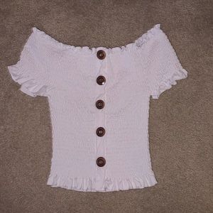 White crop top with buttons going down.